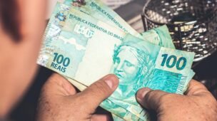 um homem olhando uma nota de 100 reais